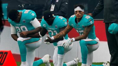 Miami Dolphins players kneel during the US national anthem before an NFL match at Wembley Stadium in London, England. Paul Childs / Reuters