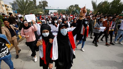 Iraqi demonstrators wear protective face masks, following the outbreak of the new coronavirus, during ongoing anti-government protests in Najaf, Iraq. Reuters