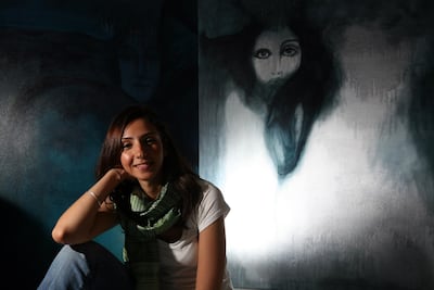 Artist Fawz Kabra, 28, poses in front of some of her art work at her Abu Dhabi home. Sammy Dallal / The National