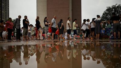 People queue to receive relief goods following a heavy rain in Zhengzhou, in China's Henan province.