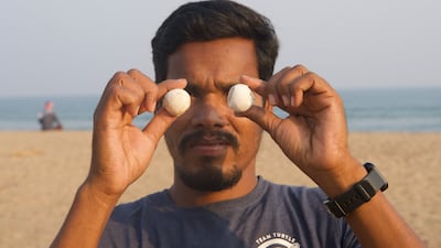 Bipro Behara, a volunteer who guards olive ridley nesting sites, holds up shells of the turtles' eggs on a beach at Podempeta in Ganjam district. Taniya Dutta / The National
