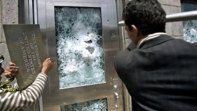 Yemenis try to break down a door of the US embassy in Sanaa yesterday where four protestors were said to have been shot dead.