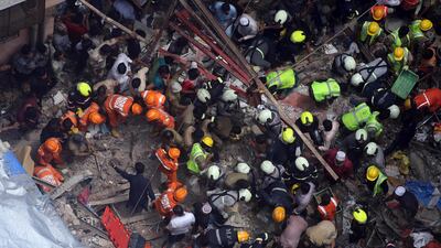 Rescuers work at the site of a building. AP Photo