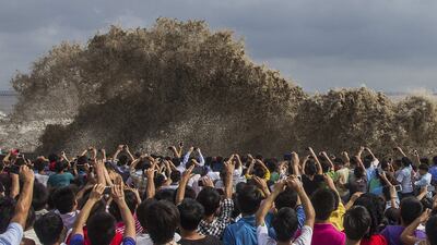Visitors take pictures of tidal waves during Typhoon Usagi in Hangzhou, Zhejiang province, China. Chance Chan / Reuters