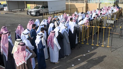 People wearing protective masks arrive to cast their vote at a polling station in Kuwait City. EPA