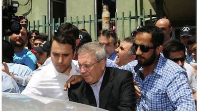 Fenerbahce chairman Aziz Yildirim, second right, is escorted by plainclothes police officers as he leaves from a hospital in Istanbul where he was being treted for suspected heart problems. He will face prosecutors over bribery charges when he is discharged. REUTERS / Stringer