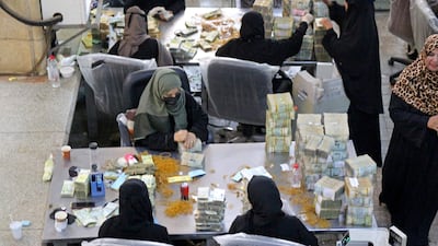 Employees count stacks of Yemeni currency at the central bank in the southern port city of Aden. AFP