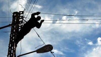 An electrician fixes electricity wires in the northern Lebanese city of Tripoli in 2012 after clashes between pro- and anti-Assad factions. Dimitar Dilkoff/ AFP