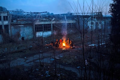 A group of Afghan migrants warm up in a bonfire next to an abandoned factory in the Bihac industrial area. JM Lopez / The National