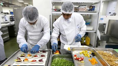 Chefs prepare starters inside the kitchen. Pawan Singh / The National