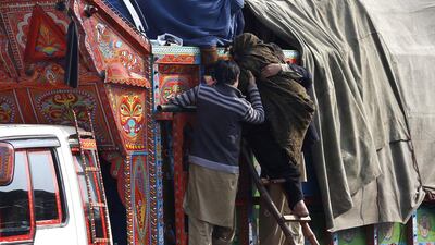 At the UNHCR offices in Peshawar, an elderly woman is helped aboard a lorry for her family’s journey to Afghanistan.
