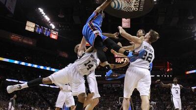 Oklahoma's Russell Westbrook goes up to dunk the ball against Gary Neal and Tiago Splitter of the San Antonio Spurs