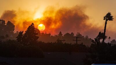 The morning sun rises through the smoke of fire in the canyons east of North Tustin on Monday, October 26, 2020. Firefighters were aggressively battling a vegetation fire that broke out in the hills near Silverado in Orange County as strong wind gusts pushed it. Mark Rightmire/The Orange County Register via AP