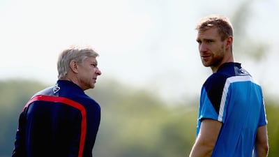 Manager Arsene Wenger of Arsenal talks to Per Mertesacker during Wednesday's training session ahead of the FA Cup final v Hull City on Saturday. Clive Mason / Getty Images / May 14, 2014