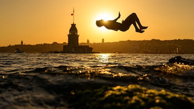 A child jumps into the sea in front of the Maiden's Tower in Istanbul, as Europe's deadly heatwave pushes eastwards. AFP