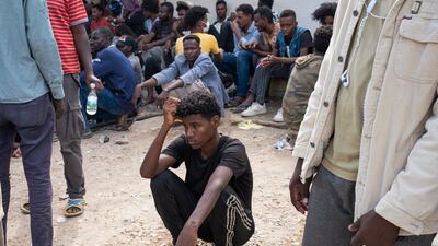 Migrants wait outside the UN refugee agency's negotiation office in Al Sarraj area in Tripoli, on October 9, 2021. Reuters