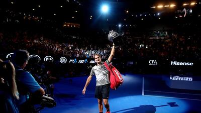 Roger Federer waves to fans in the crowd as he does a victory lap of the court with the Norman Brookes Challenge Cup after winning a match against Rafael Nadal at the 2017 Australian Open at Melbourne Park. Scott Barbour / Getty Images