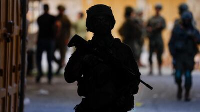 Israeli soldiers stand guard as Israeli settlers take part in a weekly tour in Hebron, in the occupied West Bank. Reuters
