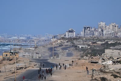 Israeli tanks block the beach road to Gaza city as displaced Palestinians gather on the coastal road near Wadi Gaza after the announcement that Israel and Hamas had agreed to the first phase of a peace plan. AP