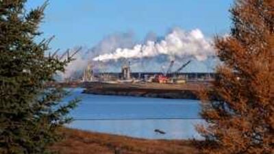 The Syncrude oil sands extraction facility behind a lake reclaimed from an old mine near the town of Fort McMurray in Alberta Province.