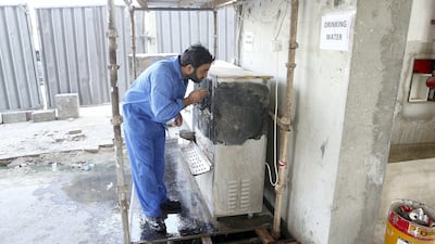 A worker drinks water during his midday break at a construction site in Dubai. Pawan Singh / The National