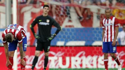 Atletico Madrid player Toby Alderweireld, left, goalkeeper Thibaut Courtois and Miranda react after conceding a goal against Malaga during their Primera Liga match at the Vicente Calderon stadium in Madrid on Sunday. Sergio Perez / Reuters / May 11, 2014