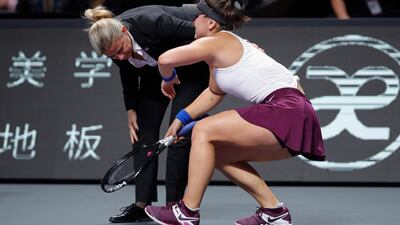 The umpire looks as Bianca Andreescu struggles to stand up after injuring her leg. AP