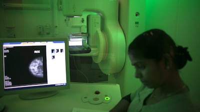 A radiology technician checks the computer inside a mobile mammogram clinic (Silvia Razgova / The National)