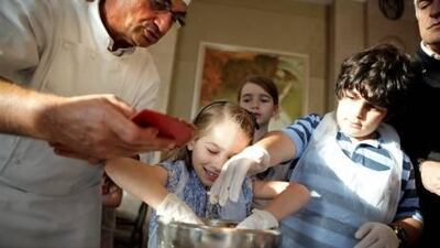 Alain Blanchard teaches children in Abu Dhabi how to make chocolate chip cookies.