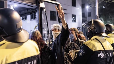 A protester is escorted into a bus by police during a pro-Palestinian protest at the University of Amsterdam in the Netherlands. EPA