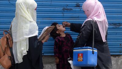 A Pakistani health worker gives the polio vaccine to an Afghan refugee as part of a campaign in Lahore. Photo: AFP