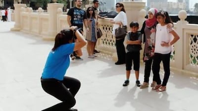 A family has their picture taken near the fountains at Dubai Mall during the Eid holiday last week - but a growing number of Emiratis are heading abroad as the holiday currently falls in high summer. Sarah Dea / The National