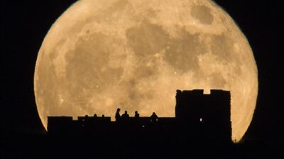 People watch the moon rise behind Coronado Heights near Lindsborg, Kansas. The brightest moon in almost 69 years is lighting up the sky in a treat for star watchers around the globe. Travis Heying / The Wichita Eagle via AP