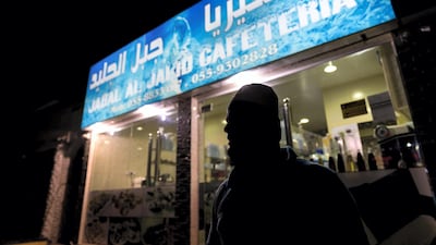 A worker waits for orders outside Jabal Al Jalid Cafeteria. Chris Whiteoak / The National