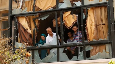 A family inspect their damaged home, which is near the Bilal bin Rabah mosque complex where hardline Sunni cleric Sheikh Ahmed al-Assir was believed to be sheltering with his supporters, in Abra near Sidon, southern Lebanon. Ali Hashisho / Reuters