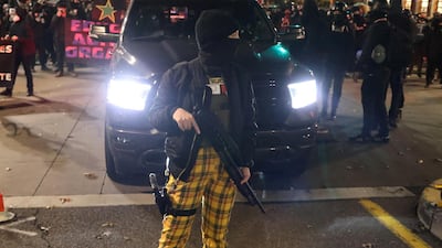 A female demonstrator carries weapons during a protest, the day after Election Day, in Portland, Oregon. Reuters