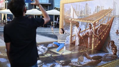 A woman poses with the 3D artwork by artist Kurt Wenner. Sarah Dea / The National