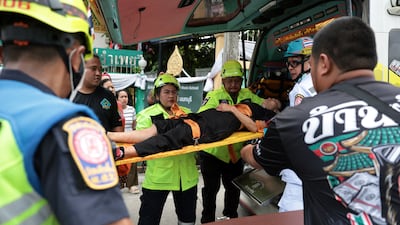 Emergency workers carry an injured teacher into an ambulance, after the attack in Thailand's Nonthaburi province. Reuters