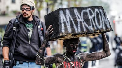 A protester made up as a slave targets president Emmanuel Macron' during the demonstration on International Workers' Day. EPA/CHRISTOPHE PETIT TESSON