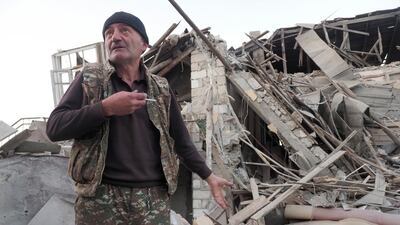 A man stands near what is left of his neighbour's house, which was hit by shelling in Stepanakert, the capital of Nagorno-Karabakh. AP