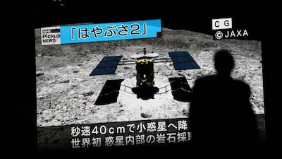 A screen displays a computer-generated image of Japan's Hayabusa2 space probe during a news broadcast. AFP