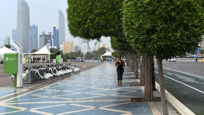 A woman jogs in the Corniche during a slight rain early Friday morning. Khushnum Bhandari for The National