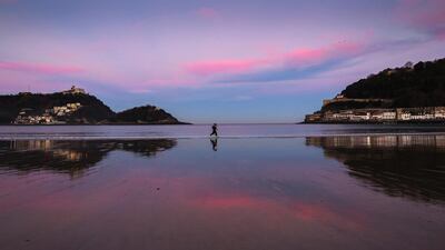 People run during sunrise at La Concha beach in San Sebastian, northern Spain. Maximum temperatures will rise up to 17°C in the north of Spain. Javier Etxezarreta / EPA
