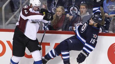 Nick Holden, left, of the Colorado Avalanche knocks over Jim Slater, right, of the Winnipeg Jets during their NHL contest on Sunday. Marianne Helm / Getty Images / AFP / February 8, 2015