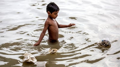 A boy takes a bath in the polluted river Ganges as plastic bags and waste items float on the water, in Kolkata, eastern India, 14 June 2017. Piyal Adhikary / EPA