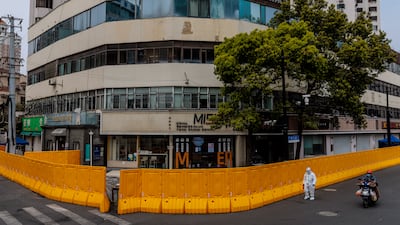 A man in protective gear walks in front of the quarantined compound, in Shanghai. EPA