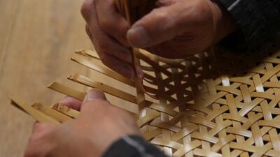 Weaving bamboo strips at the bamboo weaver Chifuyu Enomoto's studio. Kohei Yonezawa / The Art of Travel