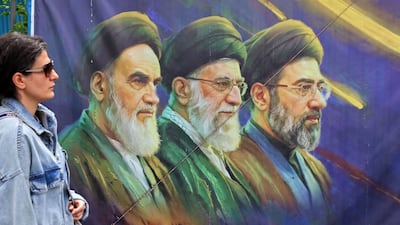 A banner featuring Iran's late supreme leaders Ayatollah Ruhollah Khomeini and Ayatollah Ali Khamenei next to new Supreme Leader Ayatollah Mojtaba Khamenei, is seen in Tehran on April 19, 2026. AFP
