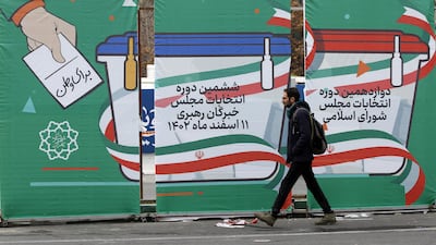 An Iranian man in Tehran passes a general election billboard for the upcoming parliamentary elections. EPA