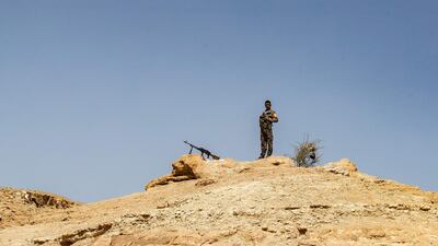 A fighter with the Kurdish-led Syrian Democratic Forces stands guard on a hilltop overlooking the Syria village of Baghouz, where two years ago ISIS made its last stand and was defeated. AFP